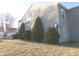 Side yard with mature evergreen trees and bushes, offering shade and curb appeal at 6651 Sonesta Dr, Indianapolis, IN 46217