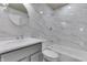 Updated bathroom featuring marble-look tile, modern vanity, and shower-tub combo at 7602 E 34Th Pl, Indianapolis, IN 46226