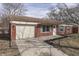 View of the home's front exterior featuring a one car garage and well-lit front entrance at 7602 E 34Th Pl, Indianapolis, IN 46226