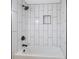 Modern tub and shower area with white tiling with black trim features a shower caddy at 8 Greenwood Trail S Dr, Greenwood, IN 46142