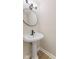 Powder room featuring a pedestal sink, decorative mirror and light fixture, with neutral paint at 8 Greenwood Trail S Dr, Greenwood, IN 46142