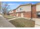 View of brick townhomes with siding, sidewalks, and small front yards under a clear blue sky at 8 Greenwood Trail S Dr, Greenwood, IN 46142
