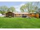 Landscaped backyard featuring a screened-in porch, hot tub, and a wooden deck with a privacy wall at 8808 Manderley Dr, Indianapolis, IN 46240