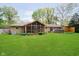 A lush green backyard with a screened porch, a patio and well-manicured lawn at 8808 Manderley Dr, Indianapolis, IN 46240