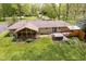 Aerial view of backyard featuring a screened-in porch, hot tub, and wooden deck, surrounded by lush greenery at 8808 Manderley Dr, Indianapolis, IN 46240