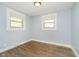 Bedroom featuring two windows with blinds and laminate floors at 8808 Manderley Dr, Indianapolis, IN 46240