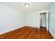 Bedroom with hardwood floors, window with blinds, and a white door at 8808 Manderley Dr, Indianapolis, IN 46240