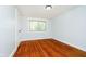 Bedroom with hardwood floors, window with blinds, and white door at 8808 Manderley Dr, Indianapolis, IN 46240