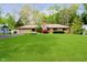 Charming ranch-style home with well-maintained lawn, stone chimney, and mature trees at 8808 Manderley Dr, Indianapolis, IN 46240
