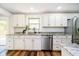 Modern kitchen features white cabinets, granite countertops, and stainless steel appliances at 8808 Manderley Dr, Indianapolis, IN 46240