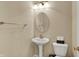 Powder room features pedestal sink, oval mirror, toilet, and towel rack, creating a functional and inviting space at 918 Rosalind Pl, Carmel, IN 46032