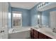 Bright bathroom featuring a soaking tub under a large window, plus a double vanity at 918 Rosalind Pl, Carmel, IN 46032