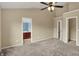 Spacious bedroom with neutral walls, carpet, ceiling fan, and view of en-suite bathroom and walk-in closet at 918 Rosalind Pl, Carmel, IN 46032