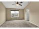 Bedroom features neutral walls, carpet flooring, a ceiling fan, and a large window offering natural light at 918 Rosalind Pl, Carmel, IN 46032