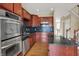 Close view of kitchen with stainless appliances, cherry wood cabinets, granite countertops and a view of the staircase at 918 Rosalind Pl, Carmel, IN 46032