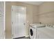 Well-lit laundry room featuring white appliances and a convenient overhead storage shelf at 918 Rosalind Pl, Carmel, IN 46032