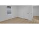Bright bedroom featuring a window with blinds, white walls, and light wood-look floors at 1209 N Centennial St, Indianapolis, IN 46222