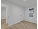 Bright bedroom featuring a window with blinds, white walls, and light wood-look floors at 1209 N Centennial St, Indianapolis, IN 46222