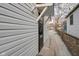 Exterior shot with white siding, narrow walkway and side door to another property at 1209 N Centennial St, Indianapolis, IN 46222