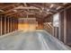 Unfinished garage with wooden rafters and concrete floor at 1209 N Centennial St, Indianapolis, IN 46222
