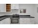 A modern kitchen featuring stainless steel appliances, white cabinets, and dark countertops at 1209 N Centennial St, Indianapolis, IN 46222