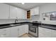 Modern kitchen featuring white cabinets, stainless steel appliances, and a window view at 1209 N Centennial St, Indianapolis, IN 46222