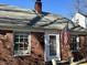 Charming brick home featuring a classic design, a well-maintained roof, and an American flag at 1230 Kessler Blvd E Dr, Indianapolis, IN 46220