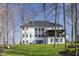 Expansive backyard featuring a modern home with ample windows, set against a backdrop of mature trees at 1355 Forest Hills Dr, Westfield, IN 46074