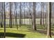 Scenic backyard overlooking lush green grass, a serene pond, and a sprawling golf course beyond mature trees at 1355 Forest Hills Dr, Westfield, IN 46074