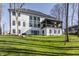 Backyard view of a modern house with a covered patio, surrounded by lush greenery and mature trees at 1355 Forest Hills Dr, Westfield, IN 46074
