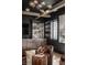 Basement bar features dark walls, leather chair, a modern light fixture, and fully stocked shelves at 1355 Forest Hills Dr, Westfield, IN 46074