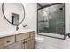 Modern bathroom features a sleek vanity, round mirror, and tiled tub shower at 1355 Forest Hills Dr, Westfield, IN 46074