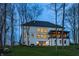 Charming home exterior featuring a covered patio with ample windows, illuminated at dusk among mature trees at 1355 Forest Hills Dr, Westfield, IN 46074
