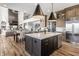 Open concept kitchen with an island, stainless steel appliances, and view to dining and living room at 1355 Forest Hills Dr, Westfield, IN 46074