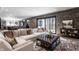 Inviting living room features a brick wall, a large sofa, and an ottoman on a patterned rug at 1355 Forest Hills Dr, Westfield, IN 46074