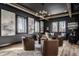 Cozy living room with comfortable leather chairs, dark walls, and natural light from the windows at 1355 Forest Hills Dr, Westfield, IN 46074