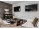 Cozy living room with brick accent wall, leather ottoman, and comfortable seating area at 1355 Forest Hills Dr, Westfield, IN 46074