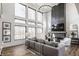 A bright living room features soaring ceilings, large windows, a cozy fireplace and wood flooring at 1355 Forest Hills Dr, Westfield, IN 46074