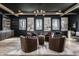 Comfortable seating area with leather chairs, center table, dark ceiling, and natural light from the windows at 1355 Forest Hills Dr, Westfield, IN 46074