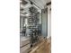 A stylish wine room with glass walls displays an extensive collection of various wines on horizontal black metal racking at 1355 Forest Hills Dr, Westfield, IN 46074