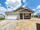 Charming single-story home featuring a garage and a welcoming front porch, set against a blue sky with scattered clouds at 1419 School Bell Dr, Greenwood, IN 46143