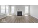 Inviting living room features a cozy fireplace, two large windows providing natural light, and beautiful hardwood floors at 14859 Amber Light Dr, Westfield, IN 46074