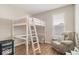 Bright bedroom featuring a loft bed with a study area, a recliner, and wood-look flooring at 15773 Eastpark Dr, Noblesville, IN 46060