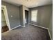 Bedroom with neutral grey walls and plush carpeting; window views of neighborhood outside at 1618 W 17Th St, Anderson, IN 46016