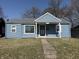 Charming single-story home featuring light blue siding and a welcoming front porch entrance at 1618 W 17Th St, Anderson, IN 46016