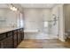 Bright bathroom featuring double vanity, a separate tub and glass-enclosed shower, and modern fixtures at 16544 Gaither Ct, Westfield, IN 46074