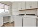 Bright laundry room features front loading washer and dryer, built-in cabinets, and ample counter space near the window at 16544 Gaither Ct, Westfield, IN 46074