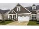 Charming home featuring brown siding, stone accents, a two-car garage and well-manicured lawn at 17099 Cole Evans Dr, Noblesville, IN 46060