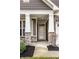 Inviting covered front porch with stone pillars, professional landscaping, and stylish front door at 17099 Cole Evans Dr, Noblesville, IN 46060