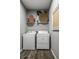 Functional laundry room with appliances, overhead shelving, and contemporary decorations at 17099 Cole Evans Dr, Noblesville, IN 46060